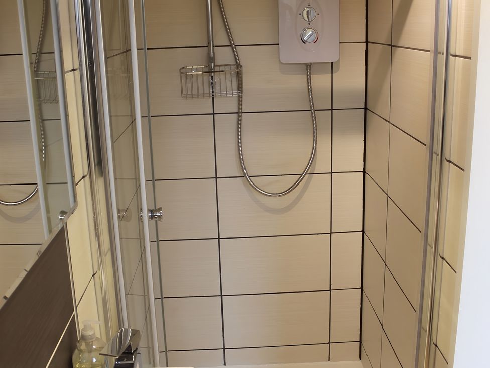 A shower with glass doors and shower controls at Erisgeir, Isle of Mull