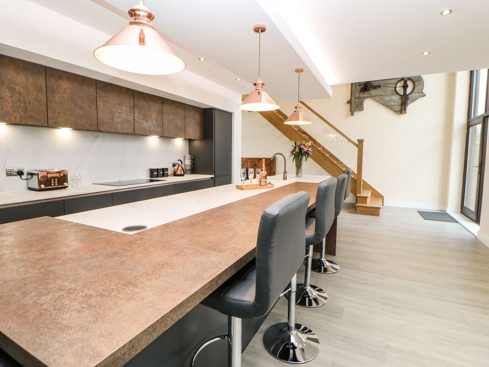 A kitchen with an island and bar stools at High Church Hill in Durham