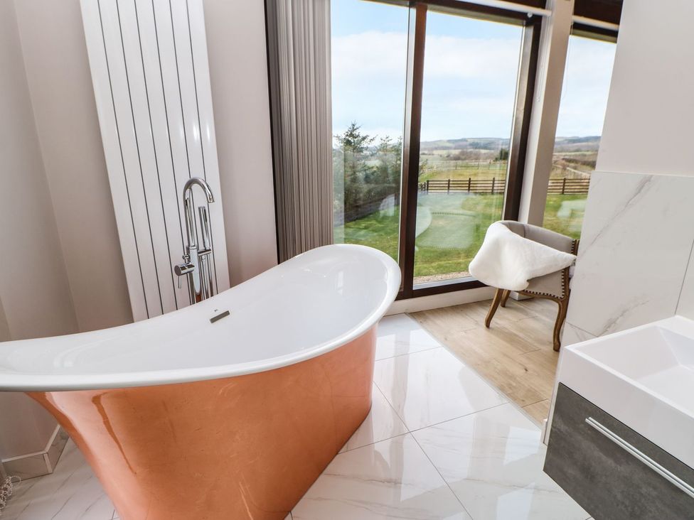 A bathroom featuring a bathtub and a chair at High Church Hill in Durham