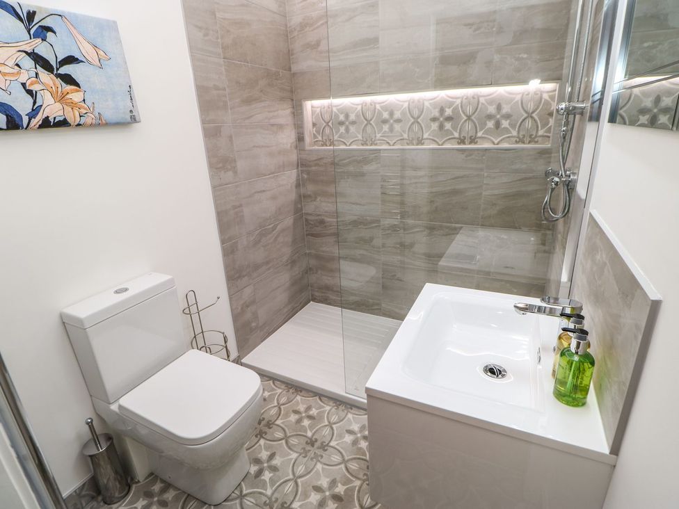 A bathroom with a shower, toilet, and sink at High Church Hill in Durham