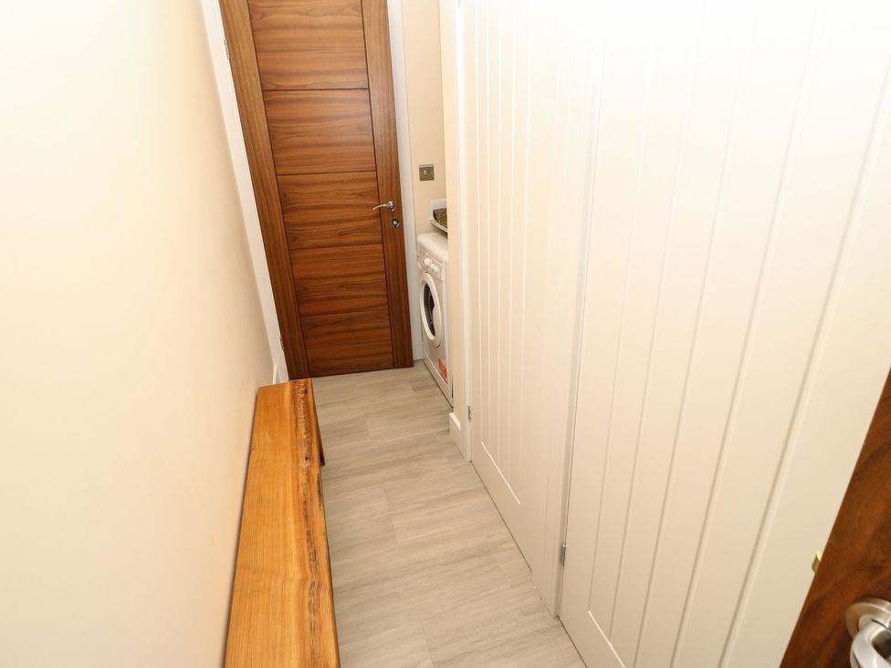 A laundry room with a washing machine and a bench at High Church Hill, Durham