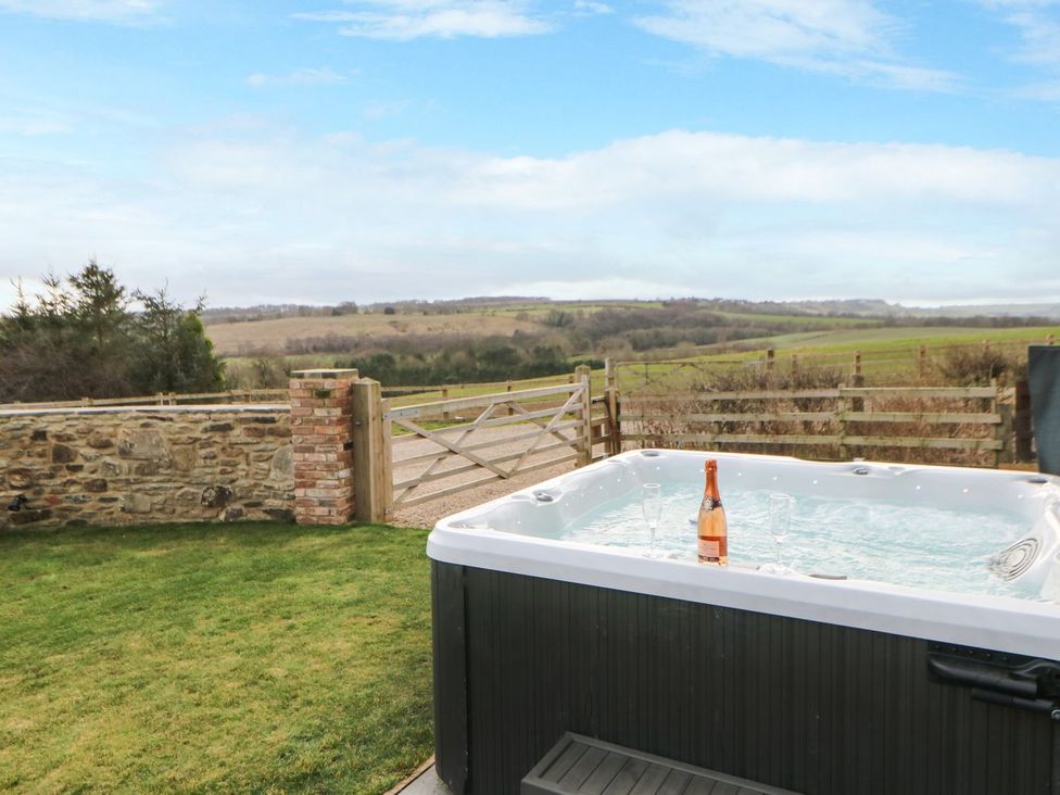 A hot tub with a bottle in the garden at High Church Hill in Durham