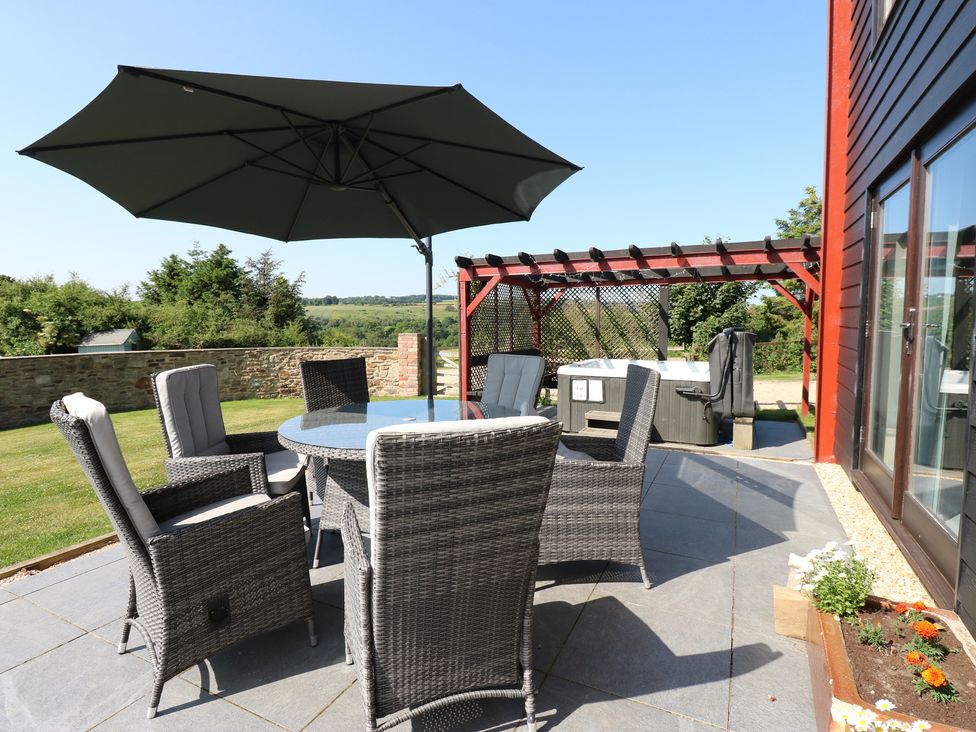 An outdoor seating area with a table and chairs at High Church Hill in Witton Gilbert