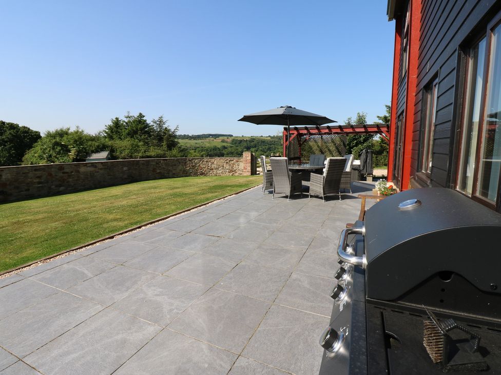 An outdoor dining area with a table and chairs at High Church Hill in Witton Gilbert