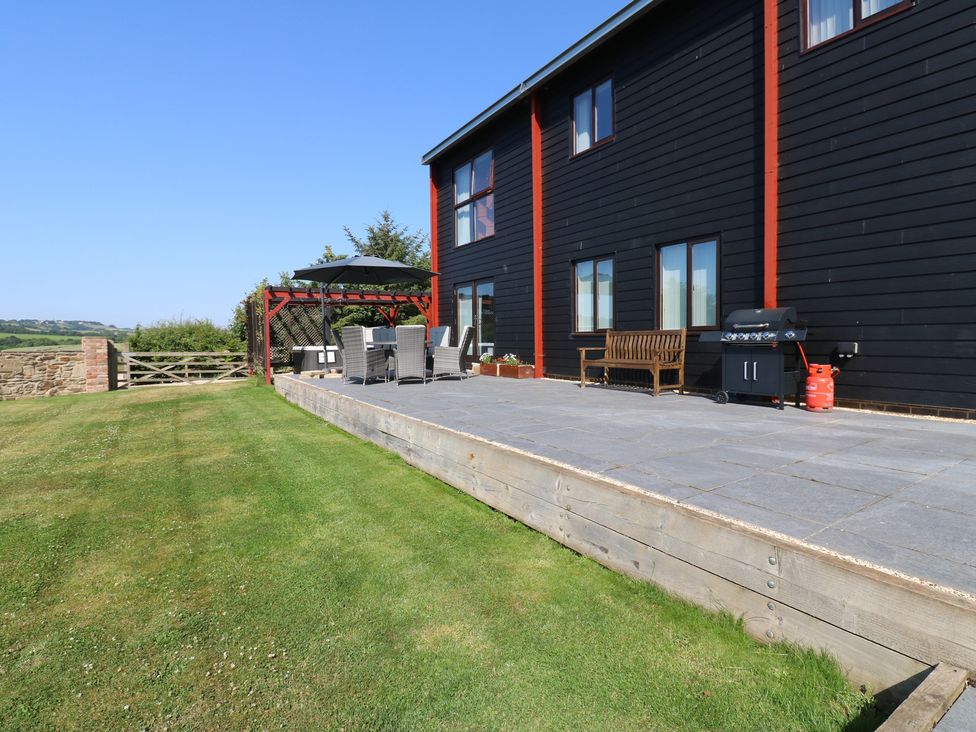 An outdoor area with seating and a barbecue grill at High Church Hill in Witton Gilbert