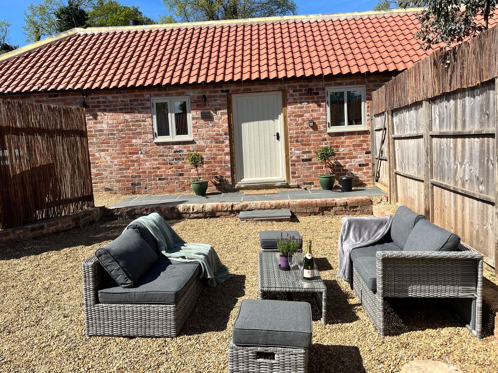 An outdoor seating area with a table and sofa at Coach Lodge in Retford