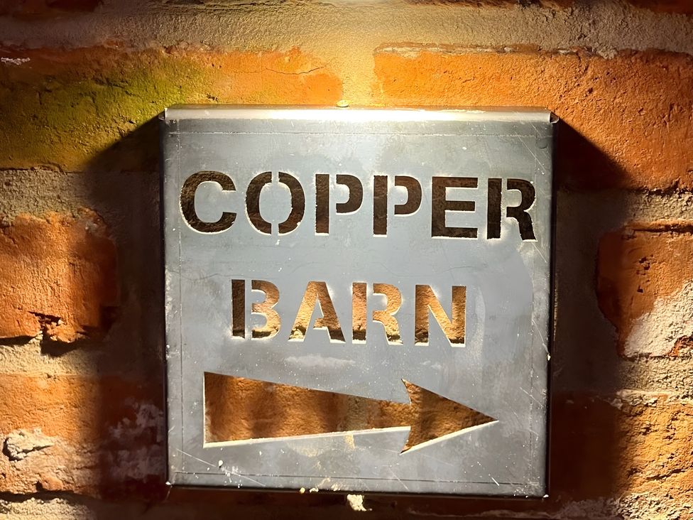 A sign that reads 'COPPER BARN' with an arrow at Coach Lodge Retford