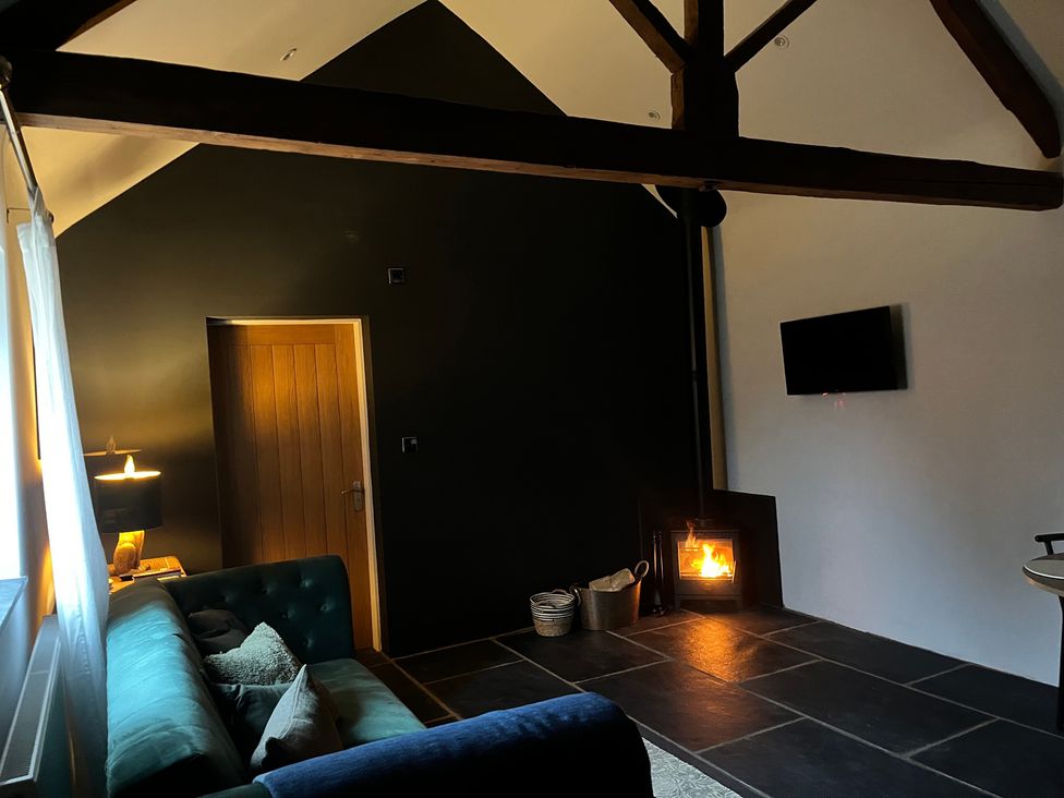 A living room with a sofa and stove at Coach Lodge in Retford