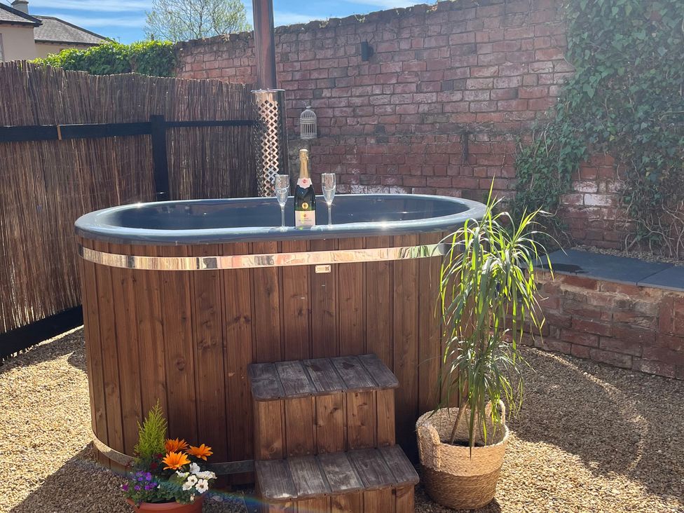A hot tub with champagne and glasses at Coach Lodge in Retford