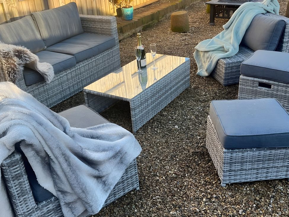 An outdoor seating area with a sofa and coffee table at Coach Lodge in Retford