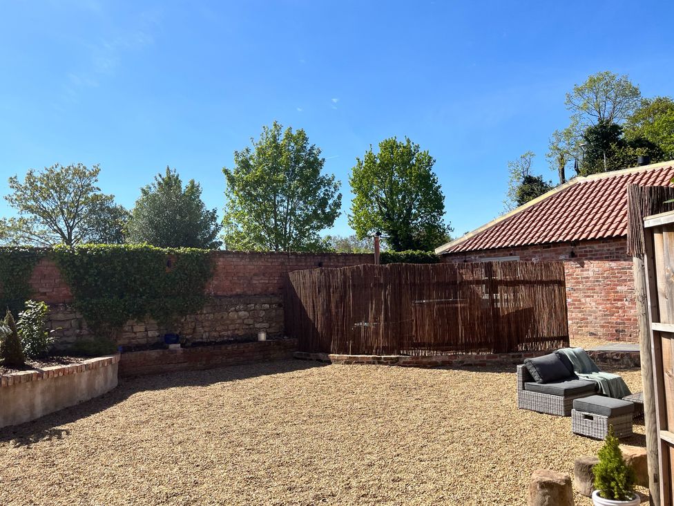 A garden with gravel and trees at Coach Lodge Retford