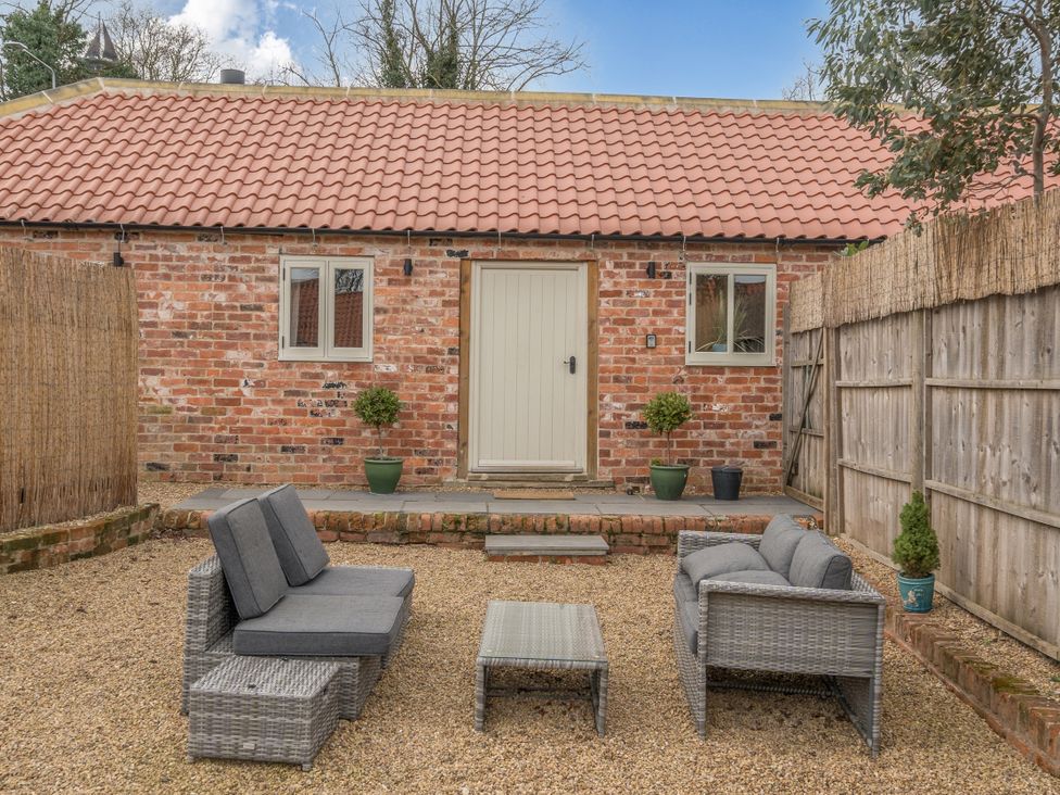A garden with seating and a brick wall at Coach Lodge in Retford