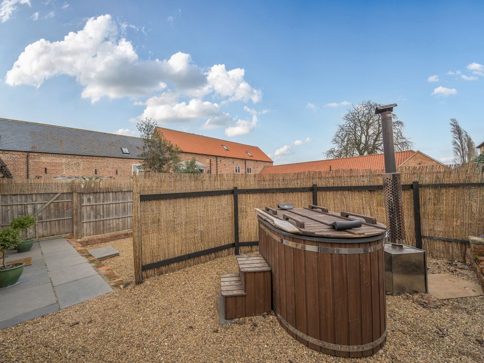 A garden with a hot tub and gravel area at Coach Lodge in Retford