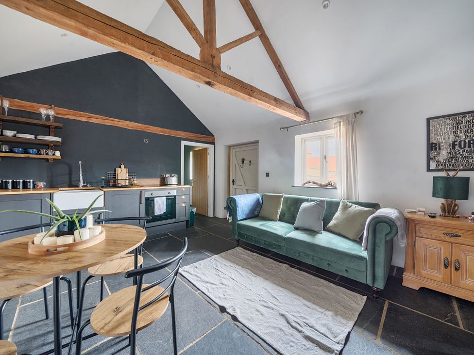 A living room with a sofa and dining area at Coach Lodge in Retford