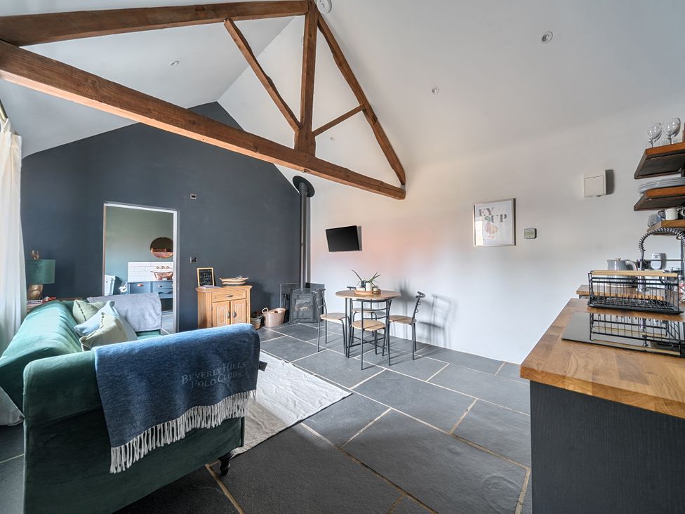 A living room with a sofa and dining table at Coach Lodge in Retford