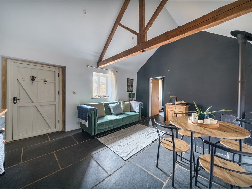 A living room with a sofa and dining table at Coach Lodge in Retford