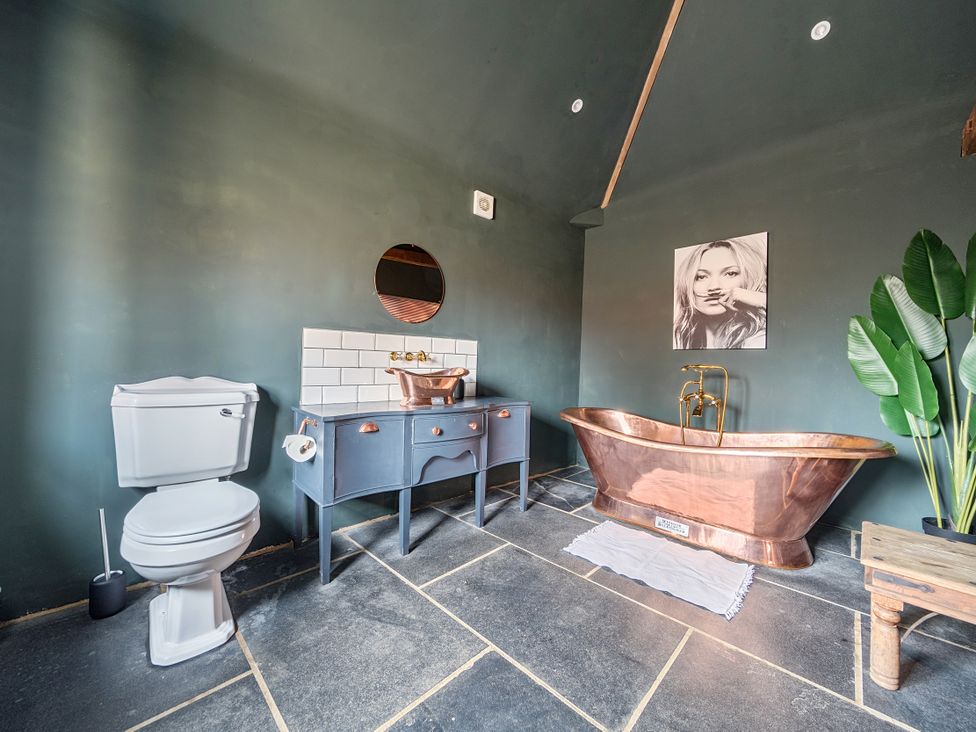 A bathroom with a bathtub and toilet at Coach Lodge in Retford