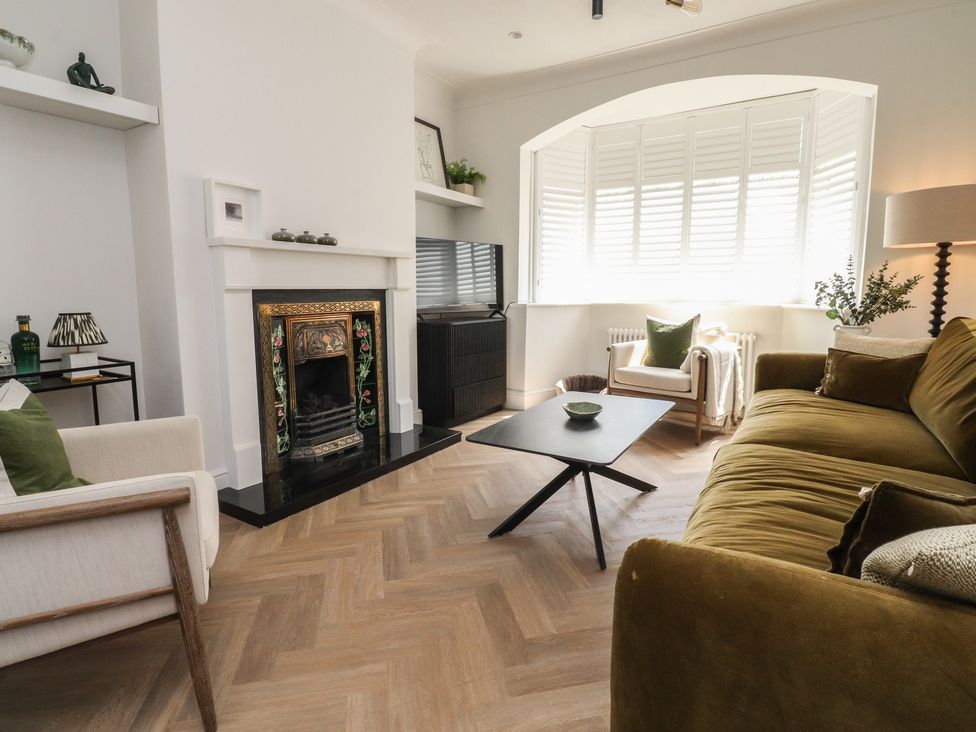 A living room with a sofa, coffee table, and fireplace at 11 Sandhurst Avenue in Lytham St. Annes