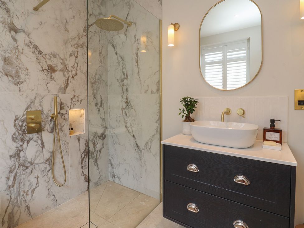 A bathroom with a shower, sink, and mirror at 11 Sandhurst Avenue, Lytham St. Annes