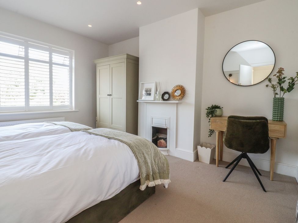 A bedroom with two beds and a wardrobe at 11 Sandhurst Avenue in Lytham St. Annes