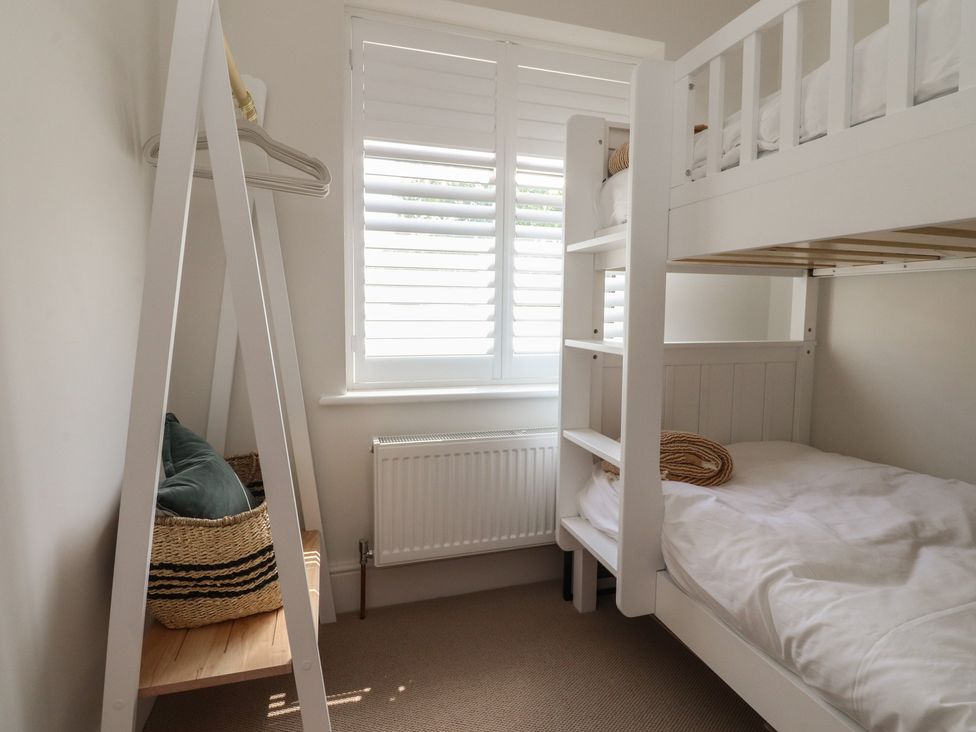 A bedroom with a bunk bed and a cushion on a seating area at 11 Sandhurst Avenue Lytham St. Annes
