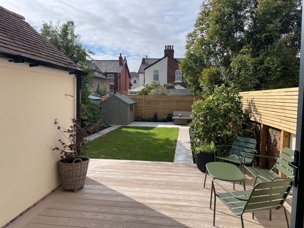 A garden with decking and chairs at 11 Sandhurst Avenue in Lytham St. Annes