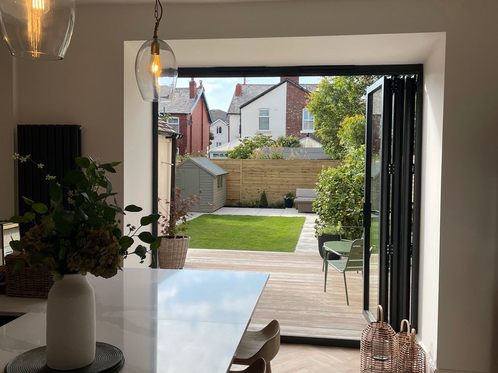 A dining room with glass doors opening to a garden at 11 Sandhurst Avenue Lytham St. Annes