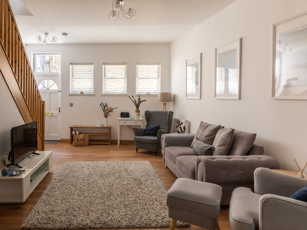 A living room with a sofa, armchairs and a television at 11A Cards Wynd Anstruther