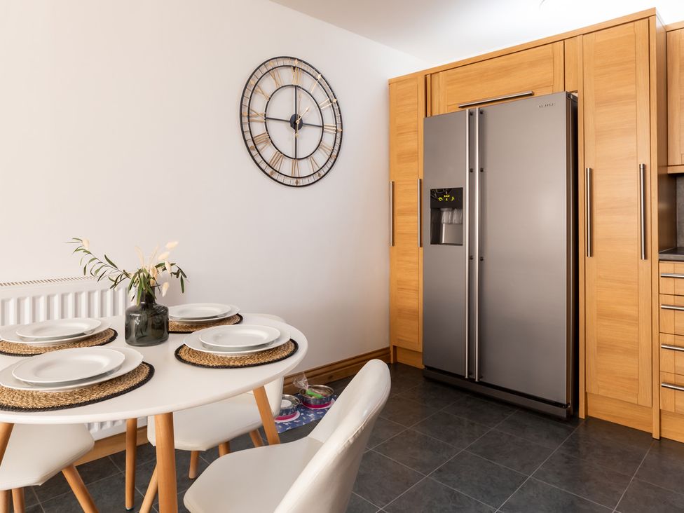 A kitchen with a dining table and refrigerator at 11A Cards Wynd Anstruther