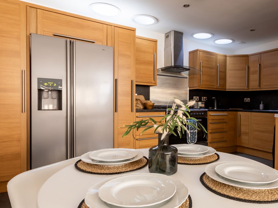 A kitchen with appliances and table settings at 11A Cards Wynd in Anstruther