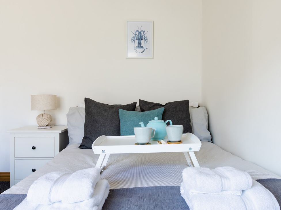 A bedroom with a bed, pillows, and a tray with tea at 11A Cards Wynd, Anstruther