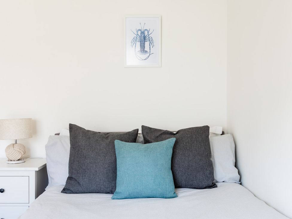 A bedroom with a bed and pillows at 11A Cards Wynd Anstruther