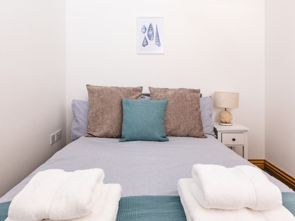 A bedroom with a bed and pillows at 11A Cards Wynd Anstruther