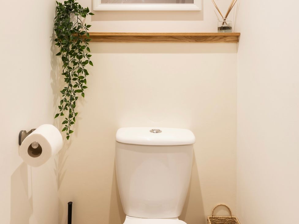 A bathroom with a toilet and a shelf at 11A Cards Wynd in Anstruther