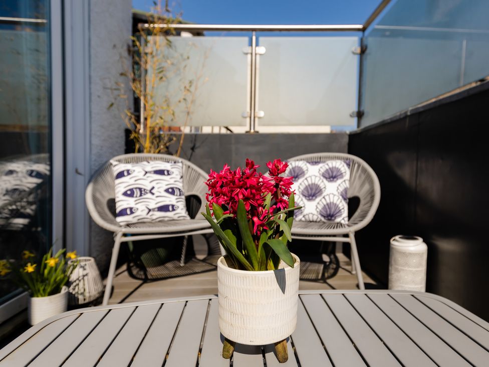 An outdoor terrace with chairs and flowers in a pot at 11A Cards Wynd Anstruther