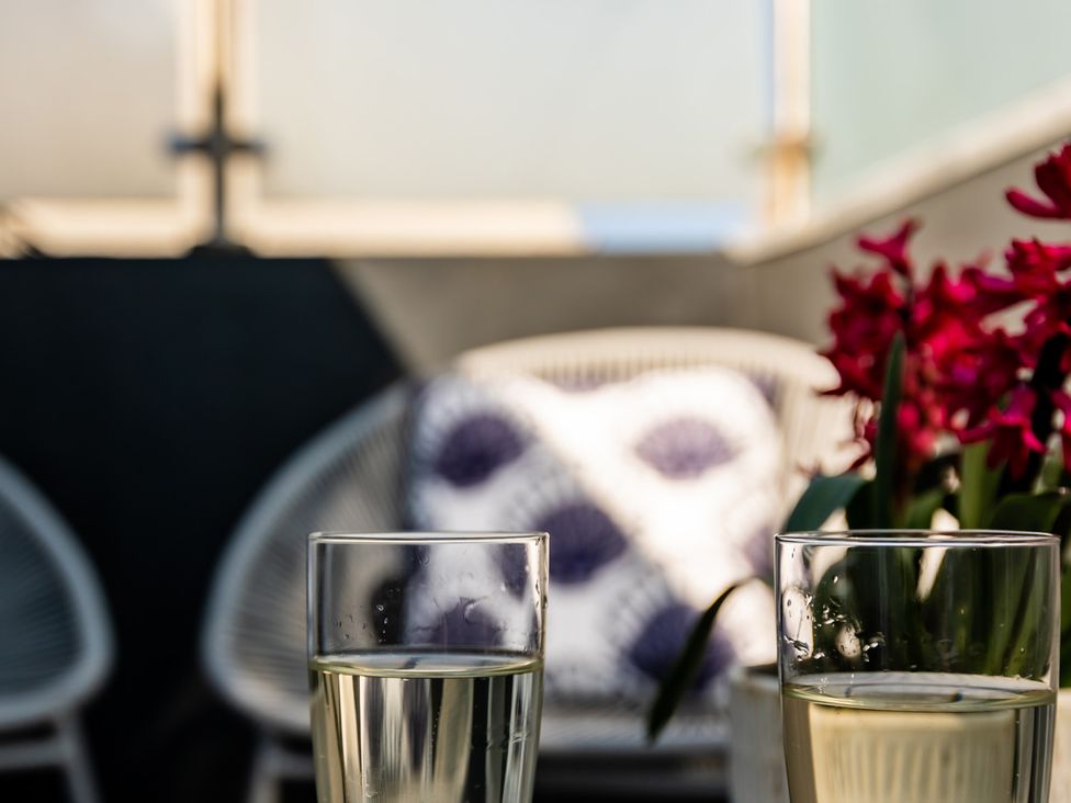 Two glasses of drink with a flower on a table at 11A Cards Wynd Anstruther