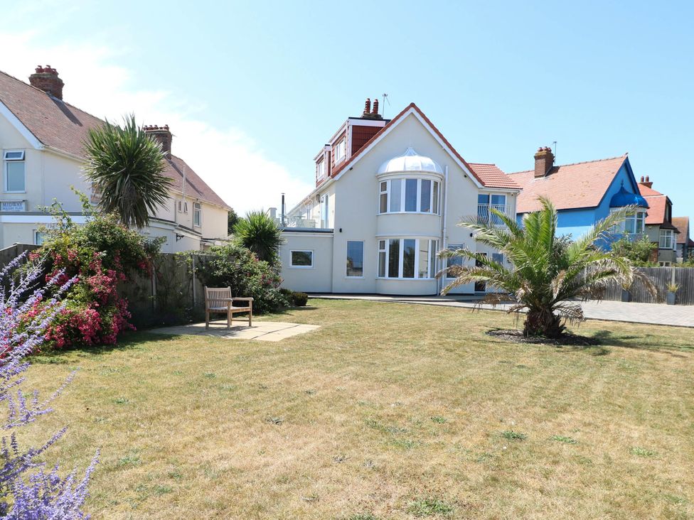 A garden with a house and palm tree at Cootiya Corner in Great Lyth