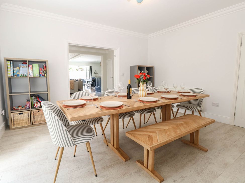 A dining room with a wooden table and striped chairs at Cootiya Corner in Great Lyth