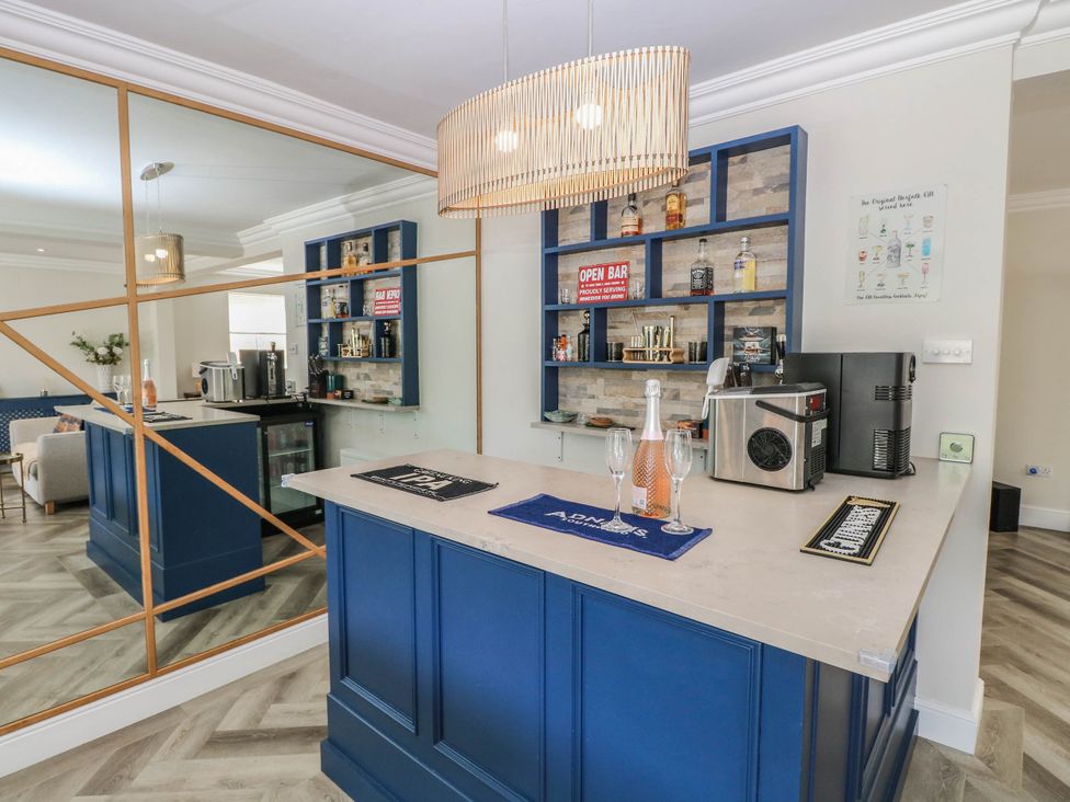 A bar area with a counter and shelves holding bottles at Cootiya Corner in Great Lyth