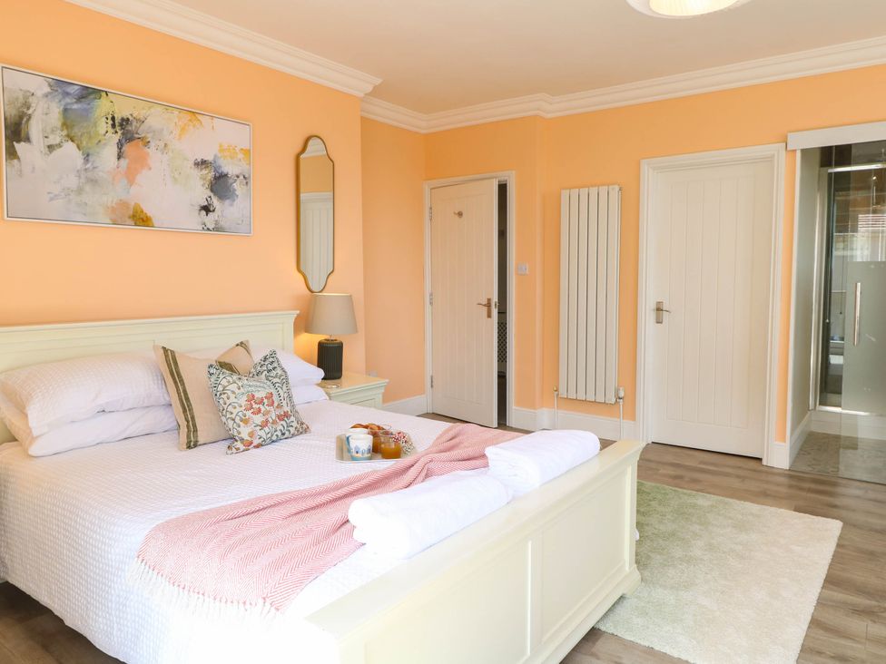 A bedroom with a bed, bedside table, and a mirror at Cootiya Corner in Great Lyth