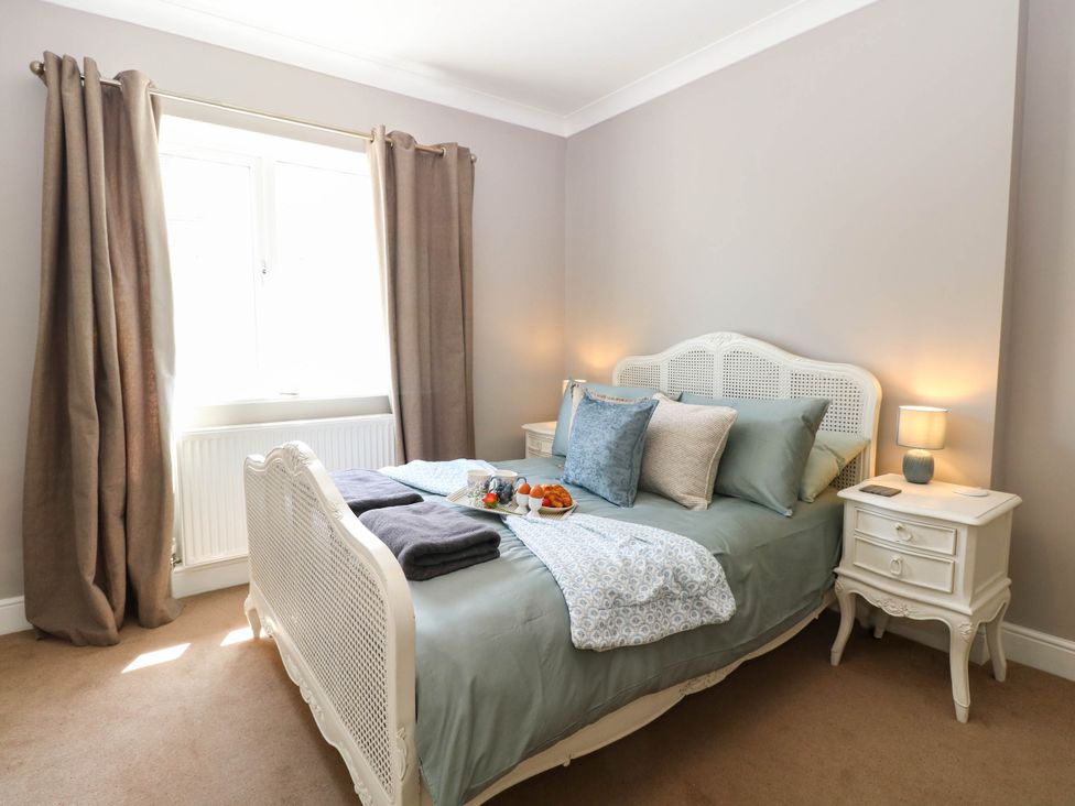 A bedroom with a bed, nightstand, and window at Cootiya Corner in Great Lyth