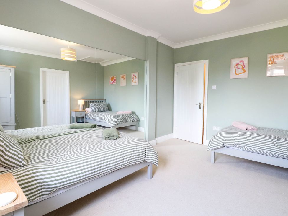 A bedroom with two beds and a wardrobe at Cootiya Corner in Great Lyth