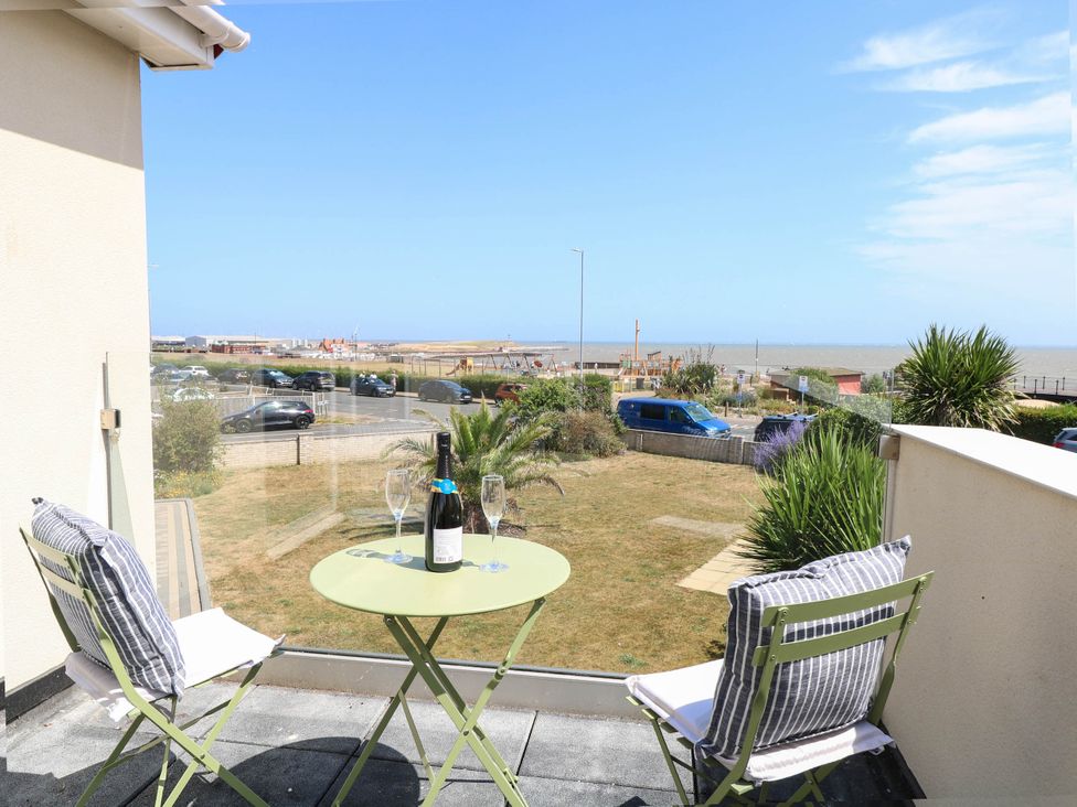 A balcony with a table and chairs overlooking the ocean at Cootiya Corner in Great Lyth