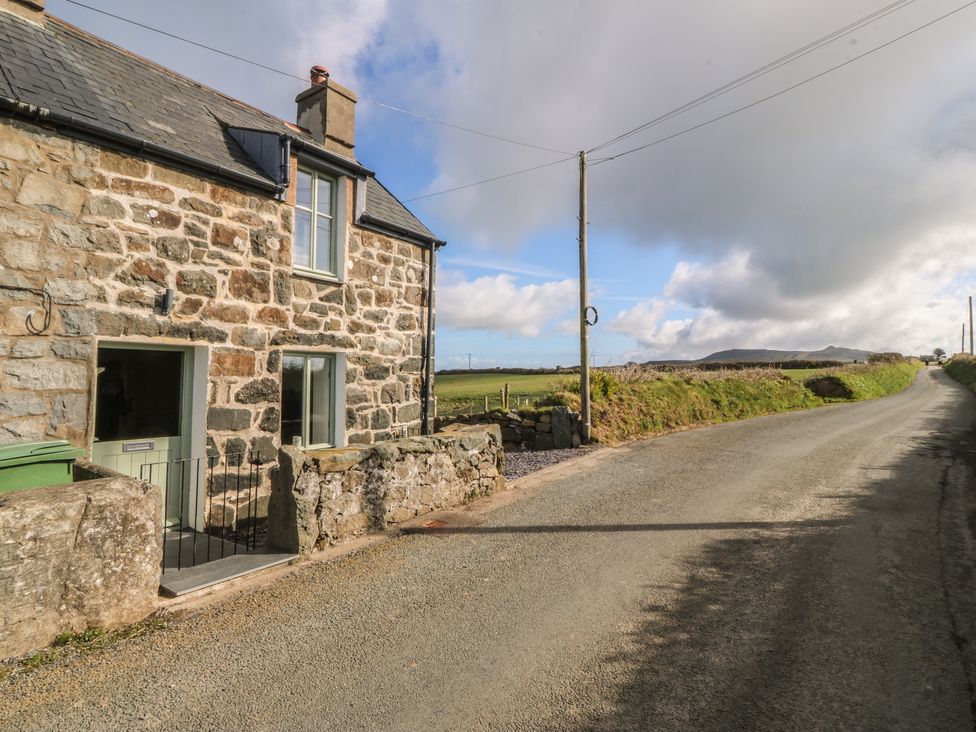 A stone house with a green mailbox on the side at Seren Fach in Pwllheli