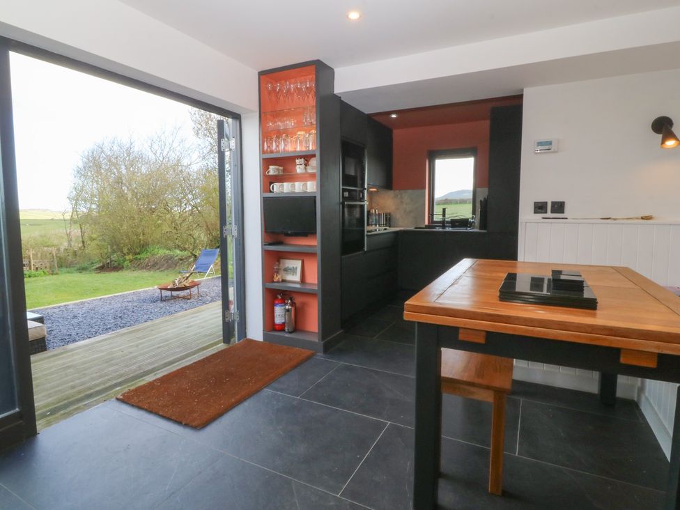 A kitchen with a table and chairs at Seren Fach in Pwllheli