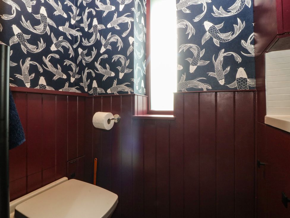 A bathroom with toilet and a window at Seren Fach in Pwllheli