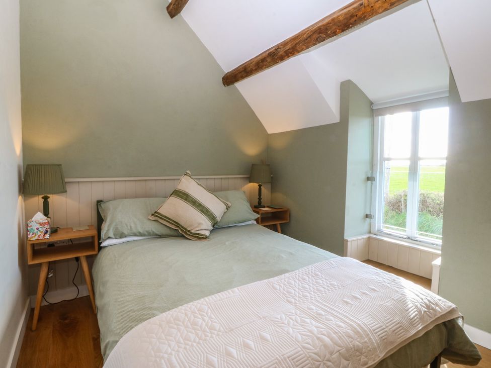 A bedroom with a bed and bedside table at Seren Fach in Pwllheli