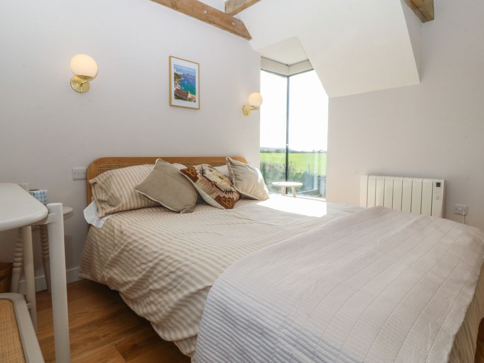 A bedroom with a bed and a window at Seren Fach in Pwllheli