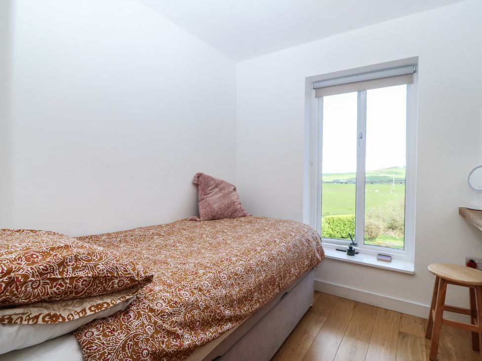 A bedroom with a bed and window at Seren Fach in Pwllheli