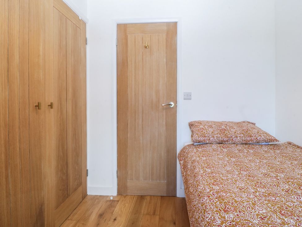 A bedroom with a bed and wardrobe at Seren Fach, Pwllheli